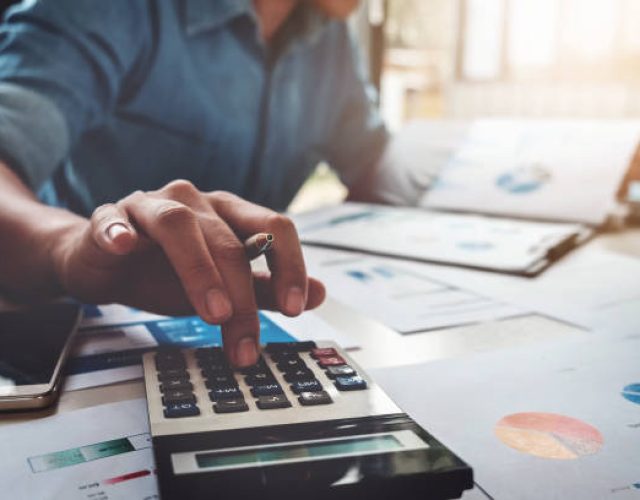 Business accounting concept, Business man using calculator with computer laptop, budget and loan paper in office.